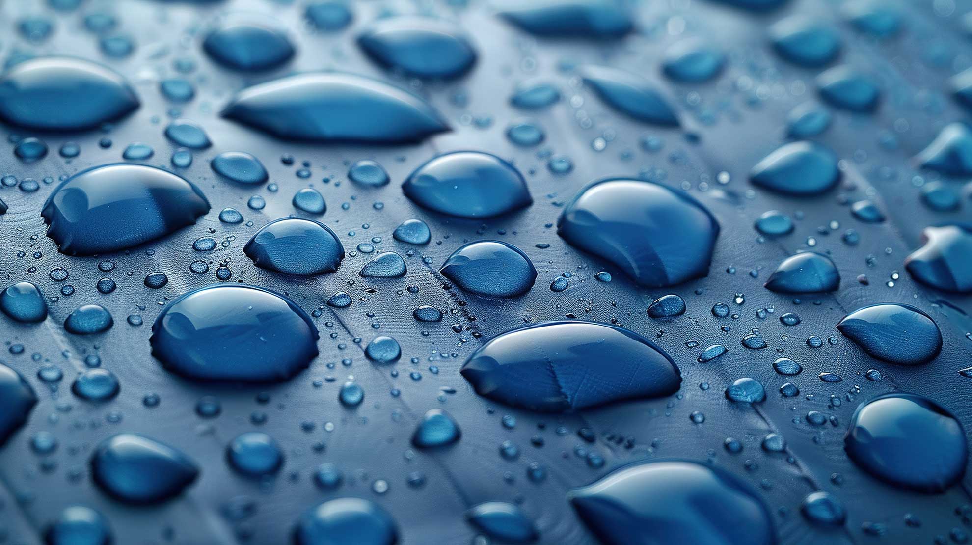 Close-up of water droplets on a paper-like surface, illustrating water resistance and sizing performance.