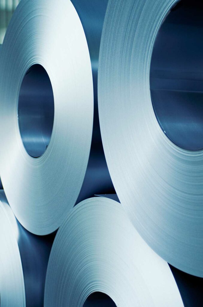 Large paper reels in an industrial setting, representing reliable sizing performance on recycled-fiber papers.