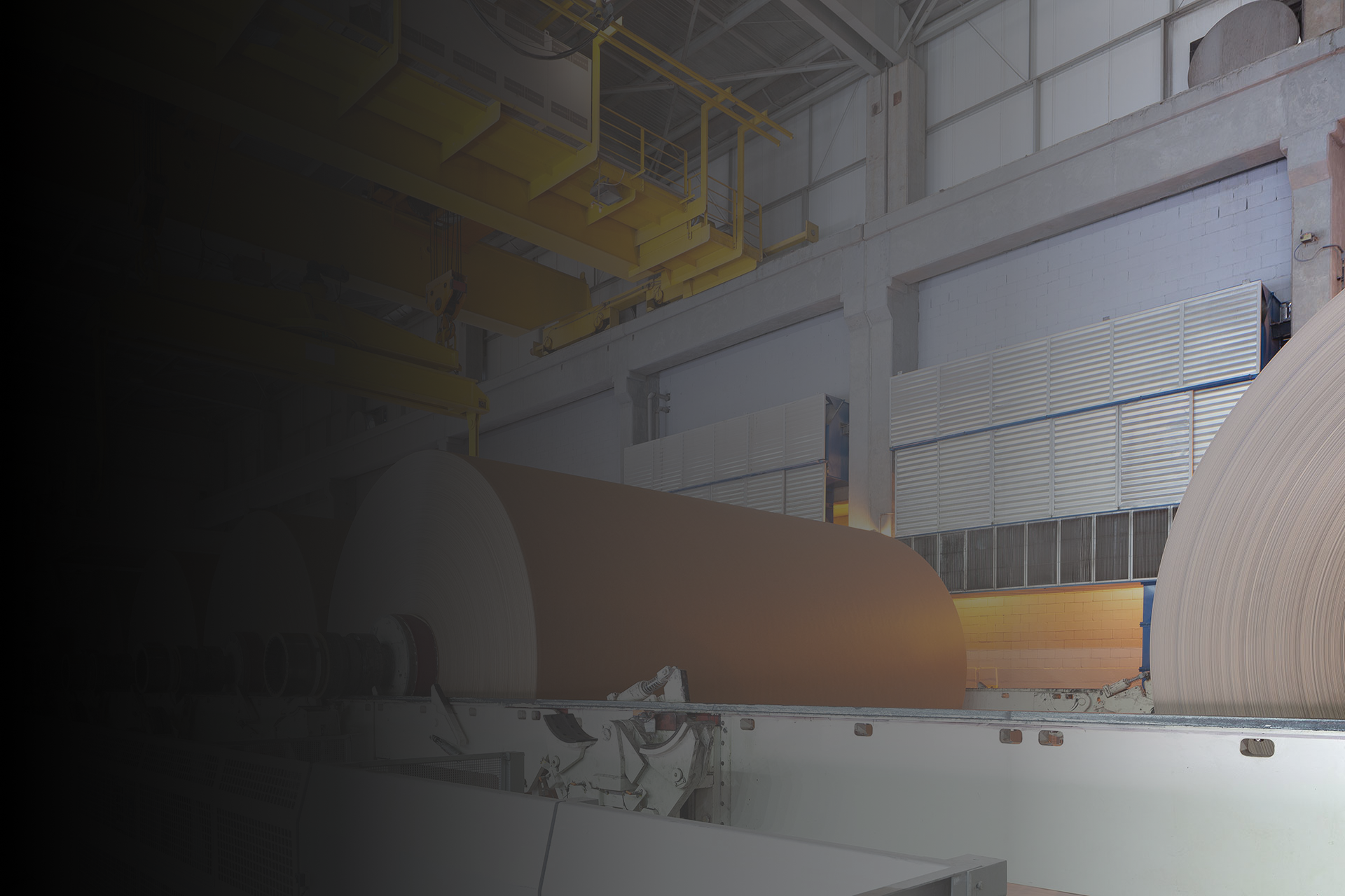 Paper machine with a large jumbo roll, representing cleaner and more efficient production through contaminant control.
