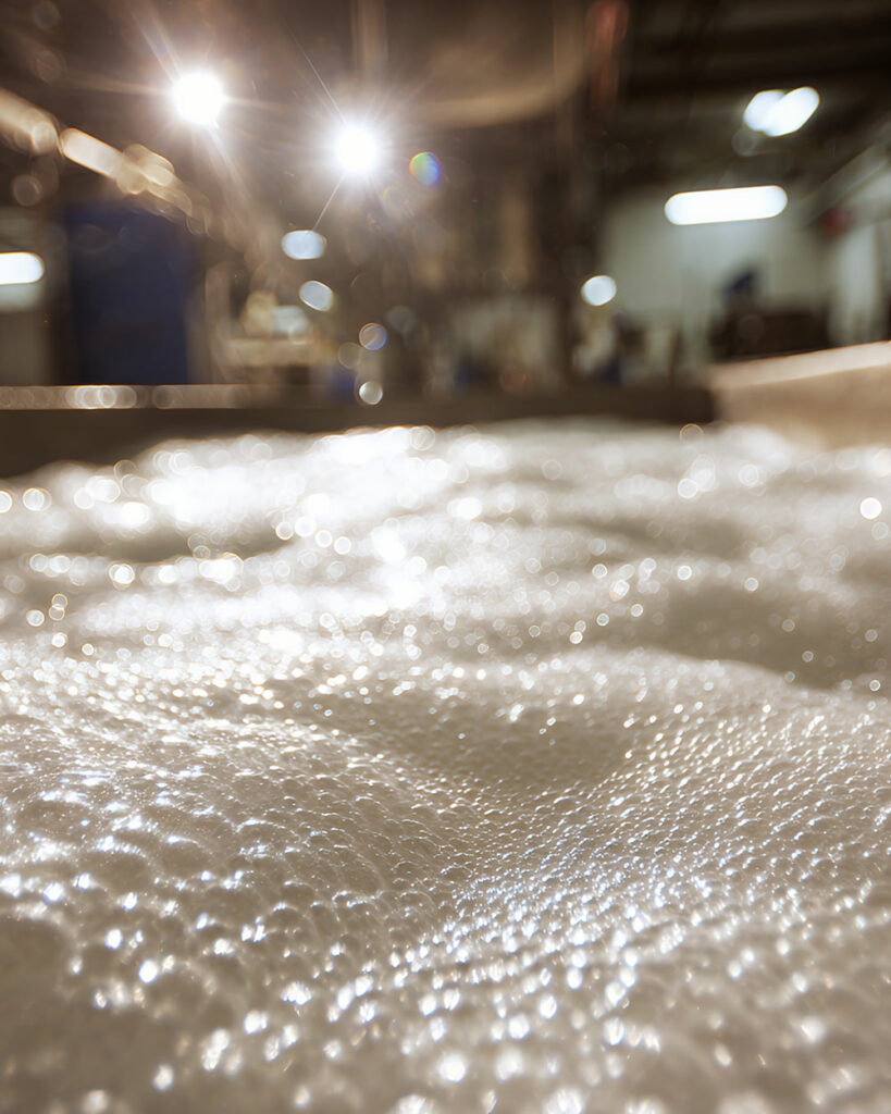 Foam on an industrial surface in a mill environment, illustrating the need for effective defoaming.